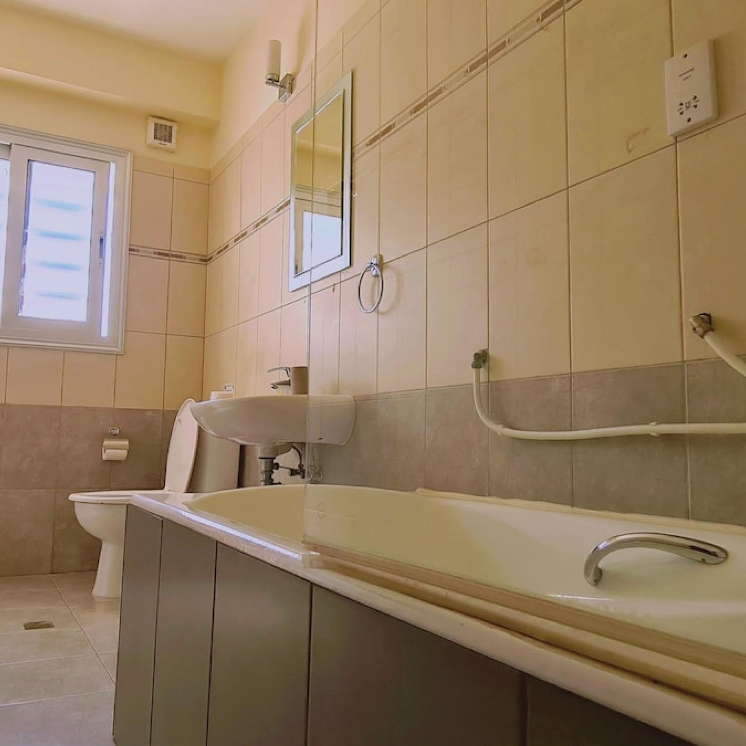 Une salle de bain avec une grande baignoire, un lavabo et un miroir.
