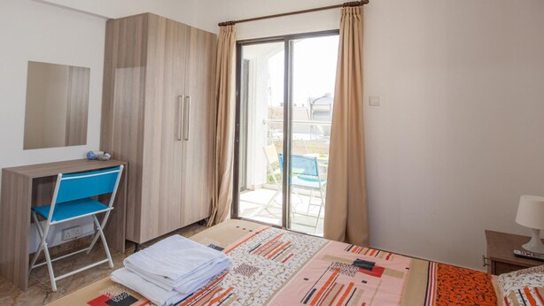 Et moderne hotelværelse med en seng, et skrivebord og en stol.
