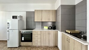 Eine moderne Küche mit ein eingebautem Ofen, einer Mikrowelle und einer Kaffeemaschine auf der Arbeitsplatte.