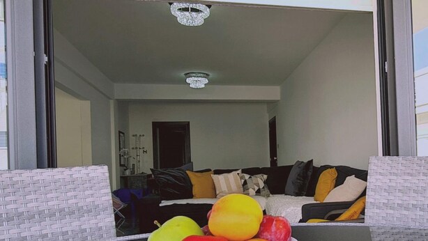 Eine Schale mit Obst auf einem Tisch in einem modernen Wohnzimmer mit einer Couch und Kissen.