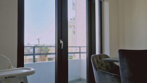 Ein Balkon mit Blick auf Gebäude und einem Stuhl.