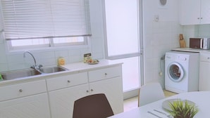 Eine moderne Küche mit Spüle, Mikrowelle und Waschmaschine.