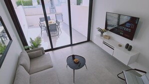 Ein modernes Wohnzimmer mit einer Couch, einem Couchtisch und einem Fernseher.