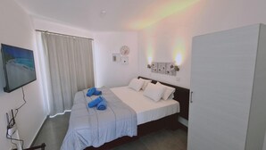 Ein Schlafzimmer mit einem Bett, einem Fernseher, einer Uhr und einer Tür.