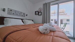 Una camera d'hotel con un letto grande, vista all'esterno e un quadro floreale appeso al muro.