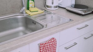 Cucina con lavello doppio, bollitore, tostapane e bilancia.