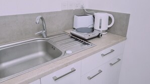 Eine Küche mit Spüle, Toaster und Wasserkocher auf der Arbeitsfläche.
