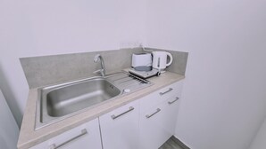 Eine Küchenzeile mit Spüle aus Edelstahl, einem Toaster und einer Kaffeemaschine.