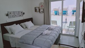 Ein Hotelzimmer mit Bett, einer Wanduhr und Blick ins Freie.