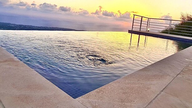 A swimming pool with a view of the sunset over the water. - 95 1 TLA - Stay Sunset Grand Palazzo (Tala)