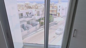 Blick von einem Balkon auf eine klare Straße und Gebäude im Hintergrund.