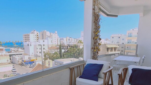 A balcony with a white sofa, a wooden chair, and a woven rug. There are two wicker baskets on the floor. - 78 LCA - Stay Kallucci s Maison de la mer (Larnaca)