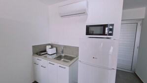 A compact kitchenette with a microwave, toaster, and sink.