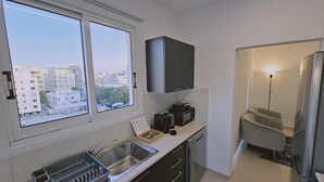 A compact kitchen with a window, a microwave, a coffee maker, and a sink. - 104 NIC - 403 Stay Cosmo City Suite (Nicosia)