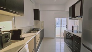 Une cuisine moderne équipée d’un lave-vaisselle, d’une cuisinière et d’une grande fenêtre.
