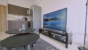 Una cocina moderna con comedor, un televisor de pantalla plana grande y una mesita.