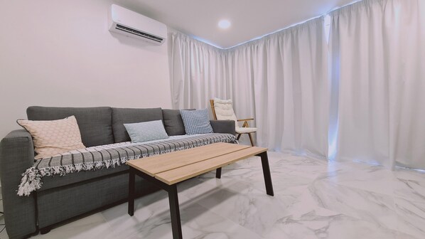 A modern living room with a grey sofa, a wooden coffee table, and a chair. - 88 PYL - Stay The Getaway (Pyla)