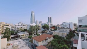 Une vue urbaine avec des bâtiments modernes, dont un gratte-ciel imposant et une grue de construction.
