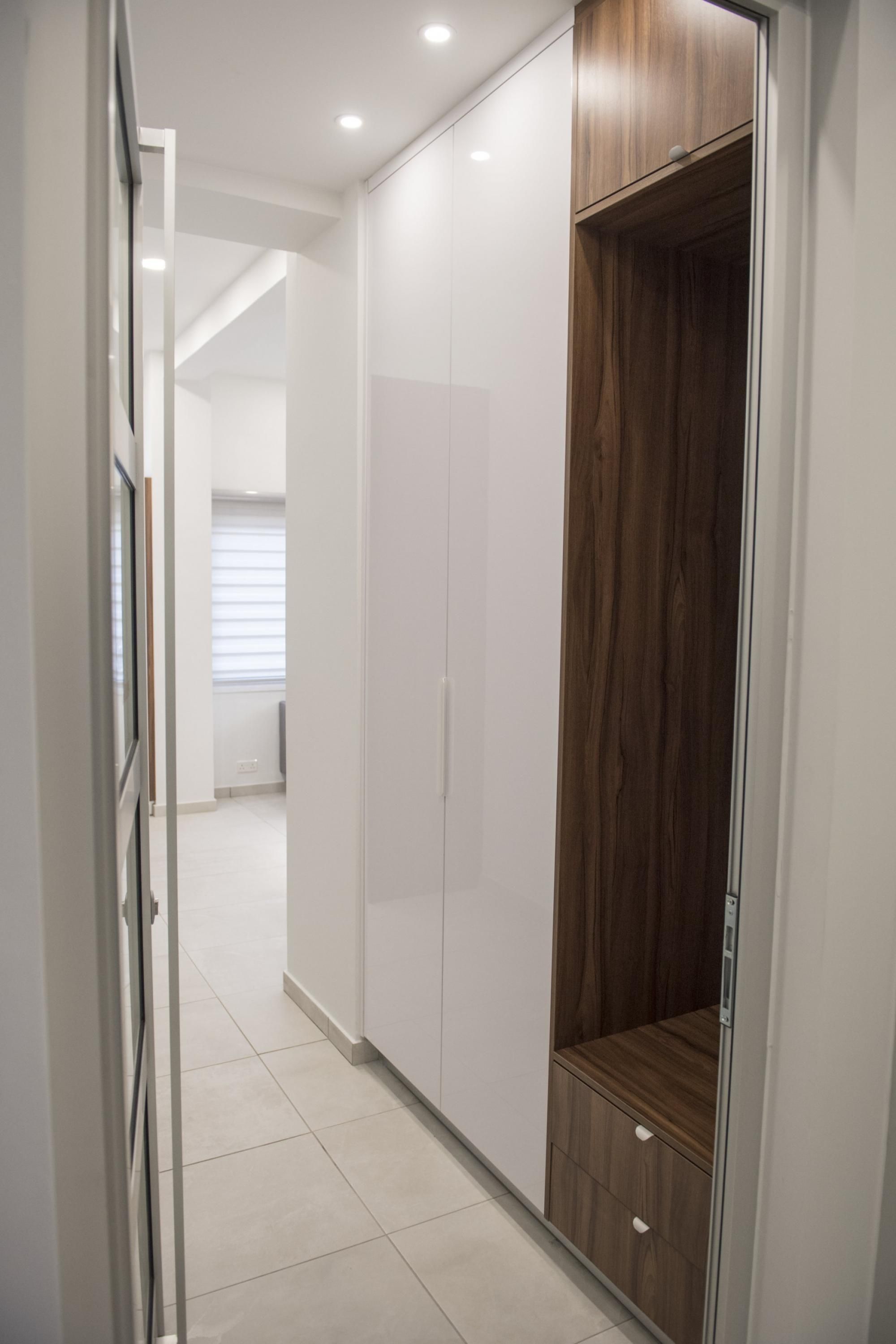 Un pasillo con un armario, un espejo y una puerta.