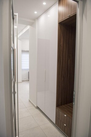A corridor with a wardrobe, a mirror, and a door. - 96 Nic1 - Stay Glam Skin Studio (Nicosia)