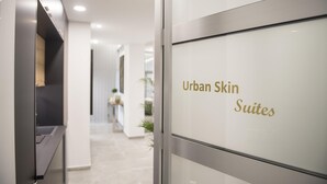 Ein Flur, der zu einem Raum führt, der mit „Urban Skin Suites“ beschriftet ist.