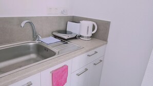 A kitchen with a sink, a toaster, a kettle, and a countertop. - 100 AN - Napa Living 23 (Ayia Napa)