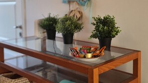 A glass-top table with a tray of snacks and three potted plants. - 99 LIM - Stay Almeria Apartment (Limassol)