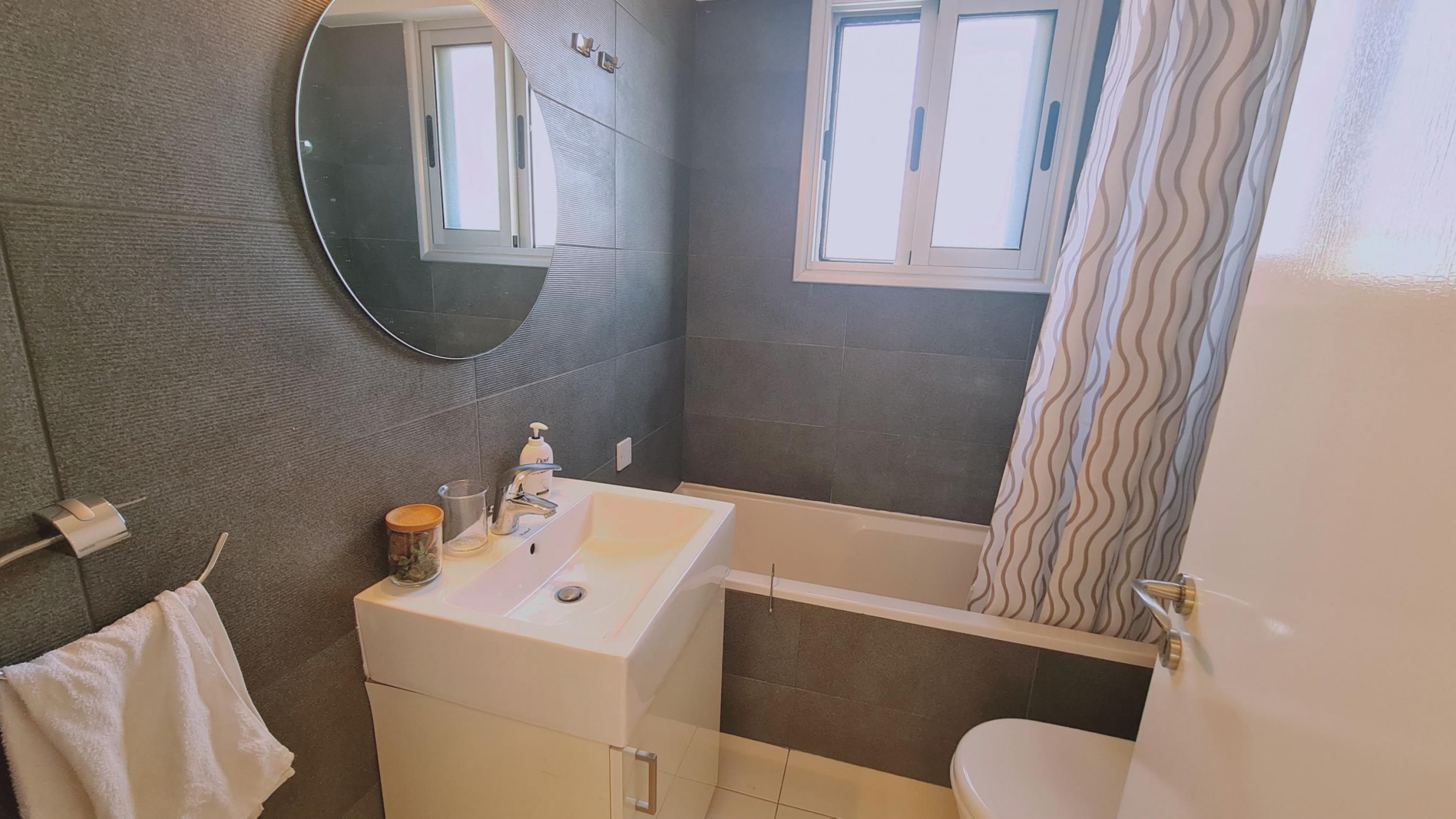 Un baño con bañera, lavamanos, espejo y ventana.