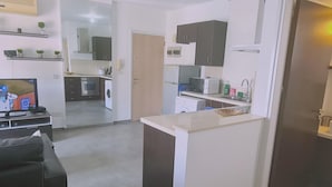 A compact living space with a kitchenette, a dining area, and a small seating area. - 17 MAK - Stay Universal Studio (Egkomi)