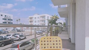 A balcony with a view of a parking lot and buildings. - 17 MAK - Stay Universal Studio (Egkomi)