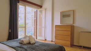 A bedroom with a bed, a dresser, a mirror, and a window with curtains. - 75 NIC - Stay Mythos Down Town House (Nicosia)