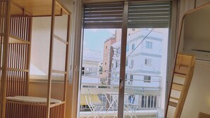 A room with a wooden bunk bed, a sliding glass door leading to a balcony, and a herringbone-patterned floor. - 57 NIC - Stay Chrysanthemum City Apartment (Nicosia)