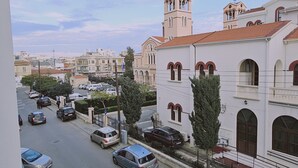 A street view with a building featuring a bell tower and arched windows. - 109 LIM 1 - Stay Olive Studio (Limassol)