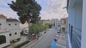A street view with buildings, parked cars, and a tree. - 109 LIM 1 - Stay Olive Studio (Limassol)