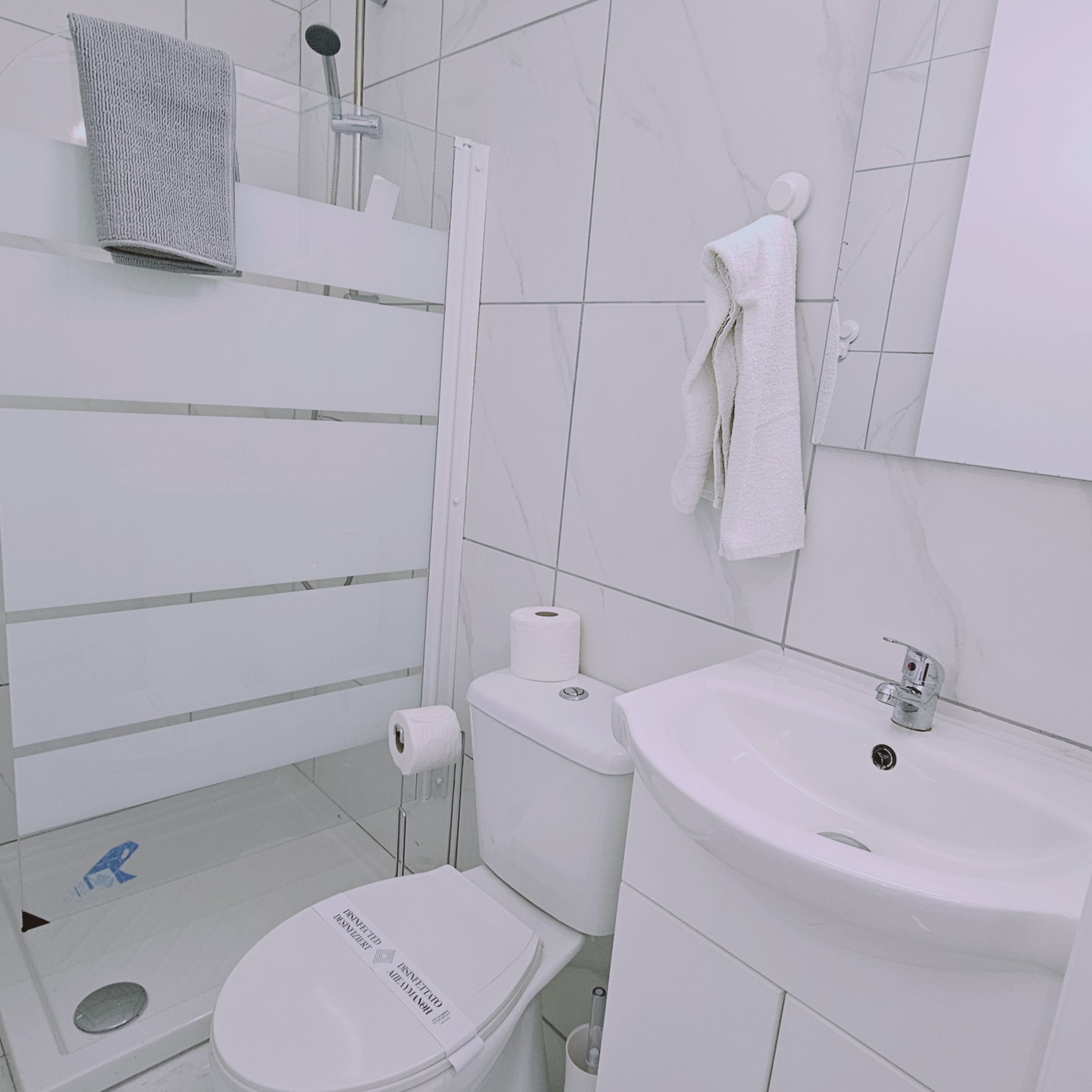 A modern bathroom with a toilet, sink, and shower.