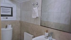 Een badkamer met een wit wastafel, toilet en een spiegel met verlichting.