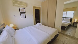 Een hotelkamer met een bed, een nachtkastje met een lamp en een kledingkast.