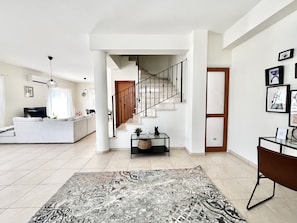 A spacious living area with a staircase, a sofa, a coffee table, and a rug. - 111 VOR - Stay Tranquility Cove (Oroklini)