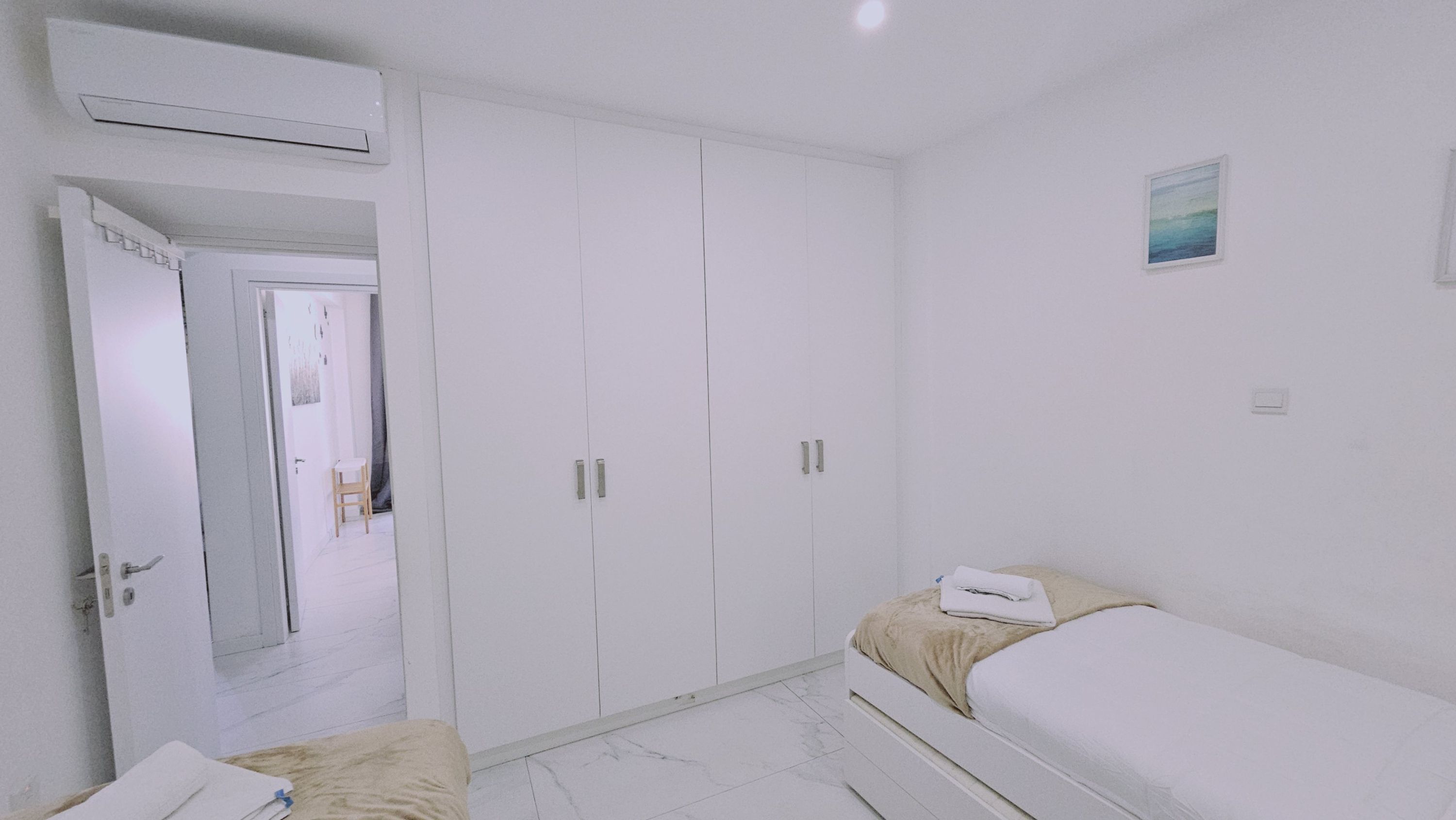 Ein Schlafzimmer mit Bett, Kleiderschrank und Klimaanlage.