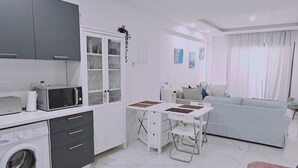 Moderni huoneisto, jossa on keittiö, ruokailutila ja olohuone.