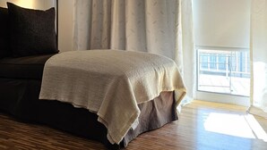 Une pièce confortable avec un lit, une lampe et une vue sur l’extérieur.
