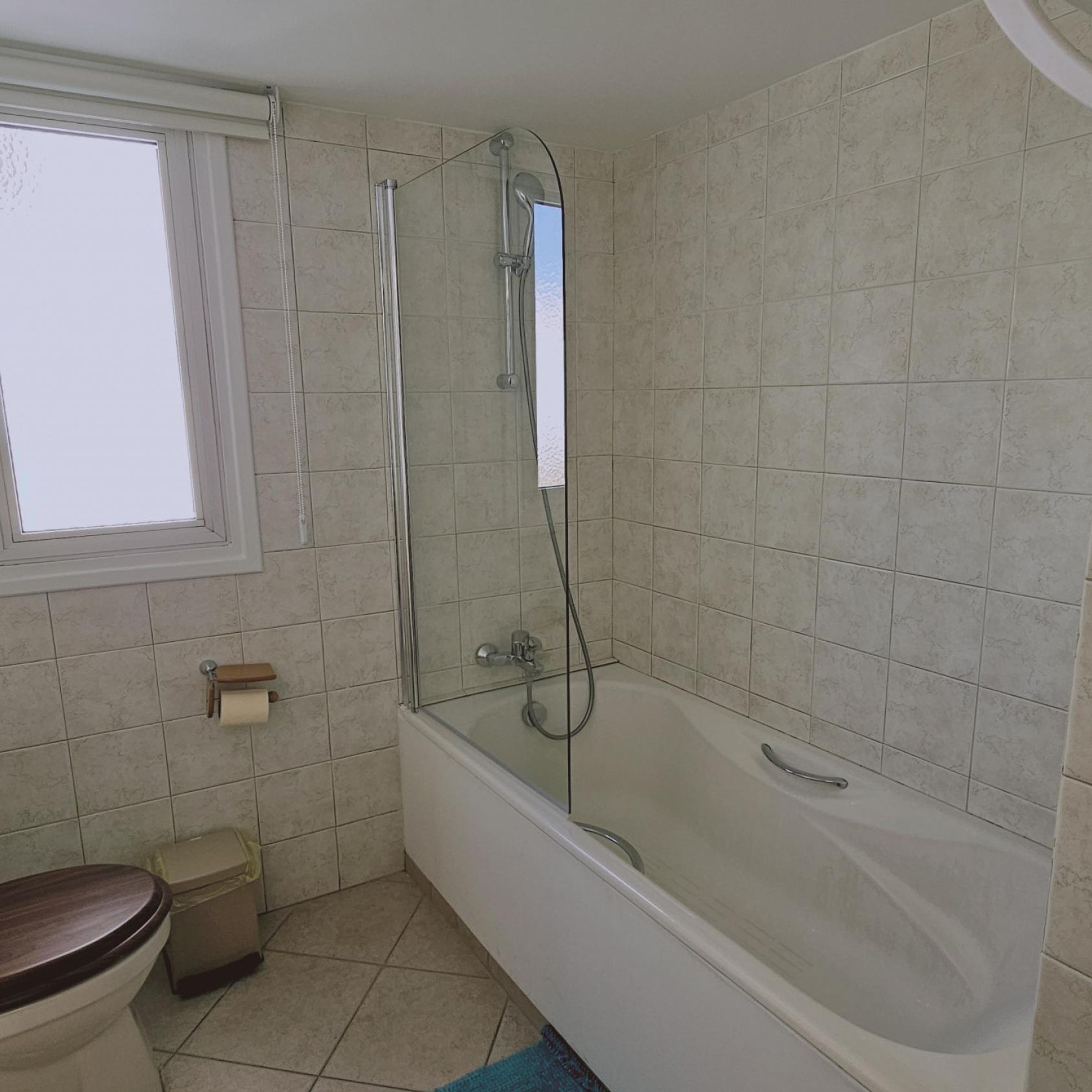 Un baño con bañera, inodoro y ventana.