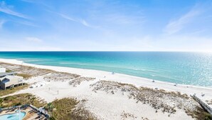 A beach resort with a pool, beach chairs, and umbrellas. - Breathtaking Gulf Views! Community Pool! Steps to the Gulf! (Pensacola Beach)