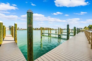 Une jetée en bois s’étendant sur une étendue d’eau calme, sous un ciel dégagé.