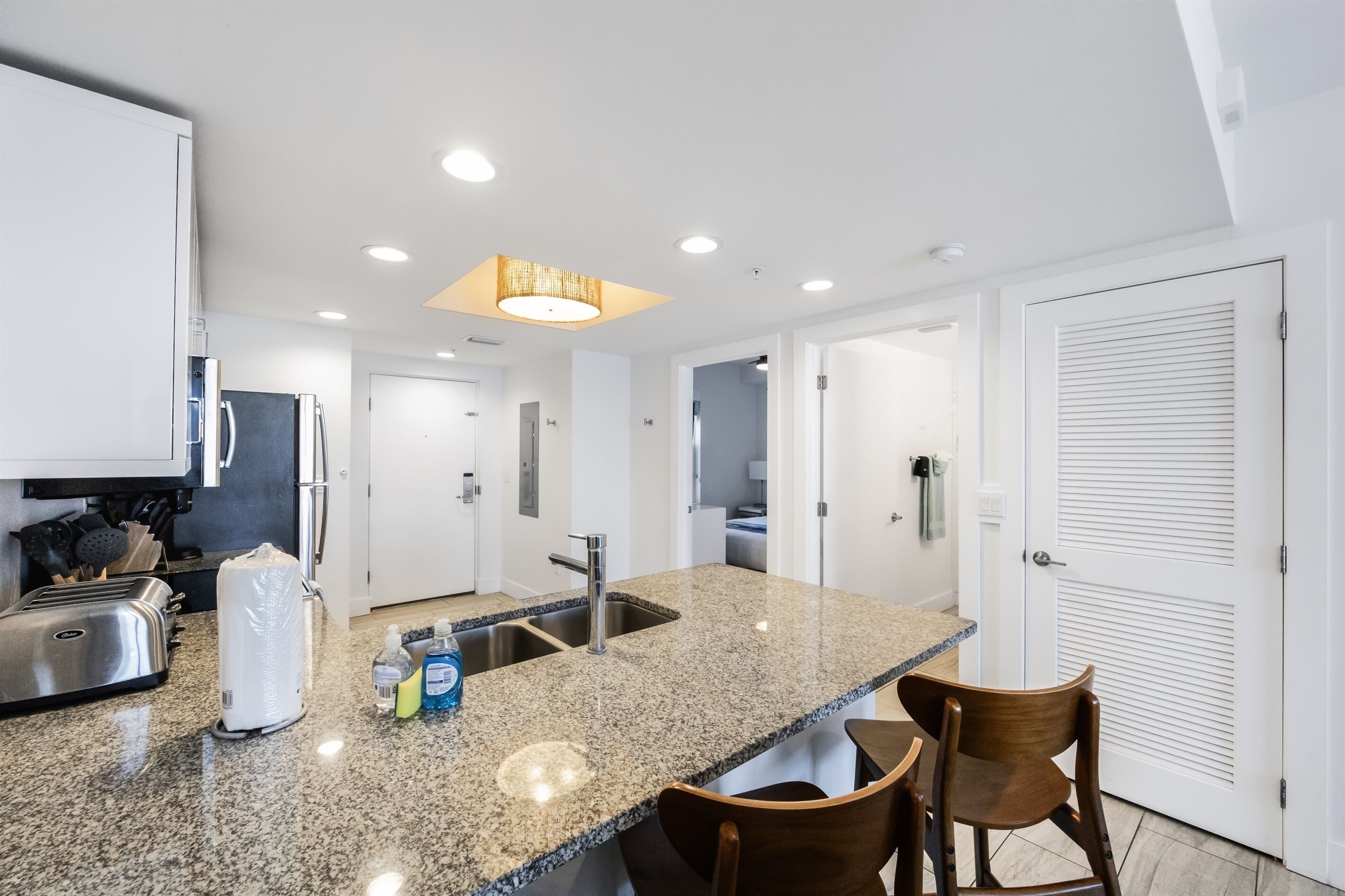 A modern kitchen with granite countertops, stainless steel appliances, and a central island with seating.