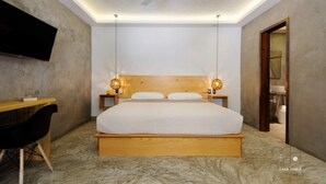 A modern bedroom with a large bed, a desk, and a TV. - Spectacular Suite Steps Away From Center La Punta! (Brisas de Zicatela)