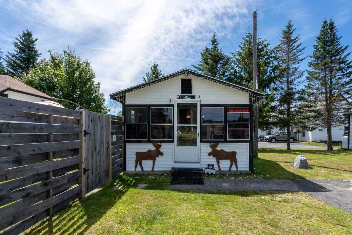Un petit bâtiment blanc avec une enseigne indiquant « MT HALE » et deux silhouettes de cerfs découpées sur la façade.