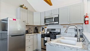A modern kitchen with stainless steel appliances, a microwave, a stove, and a sink. - Mountain Views Hot Tub Hike Mt. Washington  #4 (Carroll)