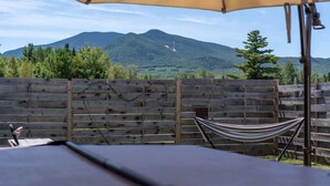 A hammock under a canopy, a wooden fence, and a mountain view. - Mountain Views Hot Tub Hike Mt. Washington  #4 (Carroll)