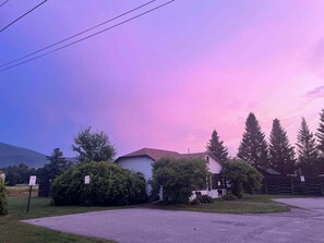 Un quartier résidentiel comprenant une maison, une allée et un panneau indiquant la présence d’un chalet.